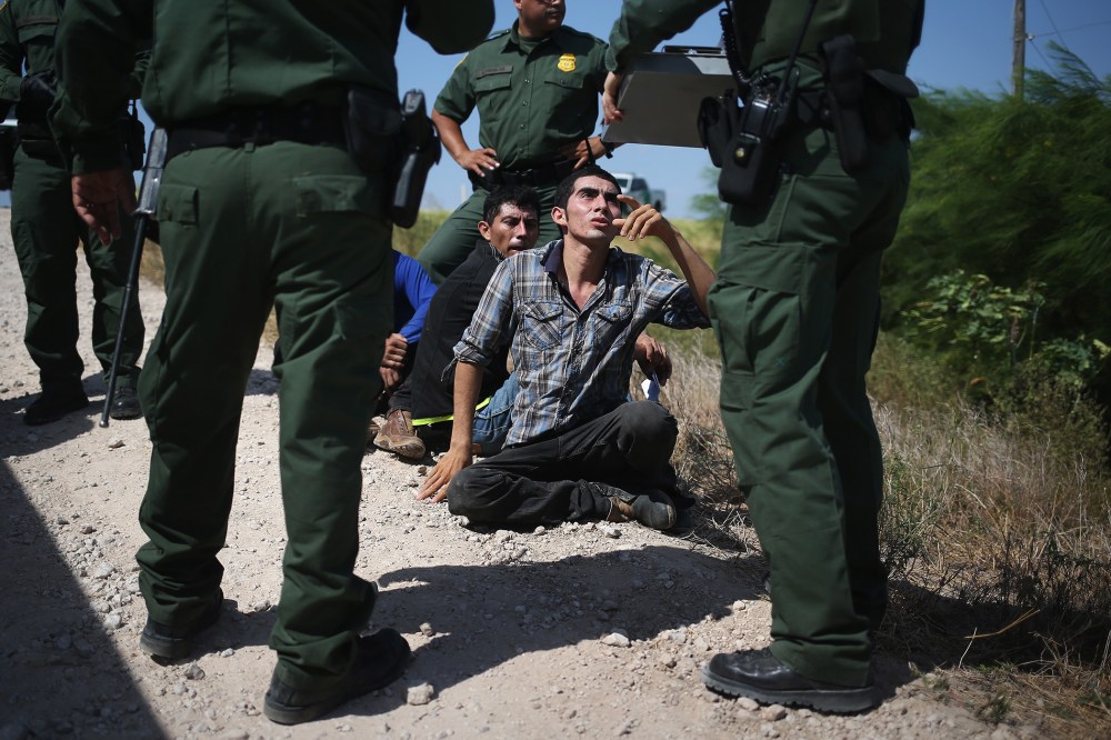 U.S. Border Patrol agents detain undocumented immigrants after they crossed the border from Mexico into the United States on Aug. 7, 2015 in McAllen, Texas. (Photo by John Moore/Getty)