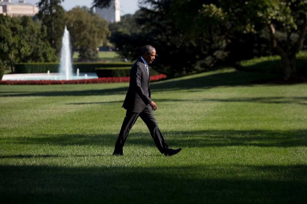 President Barack Obama walks toward the White House after landing on the South Lawn on Aug. 25 in Washington, D.C. (Photo by Andrew Harrer/Pool/Getty)