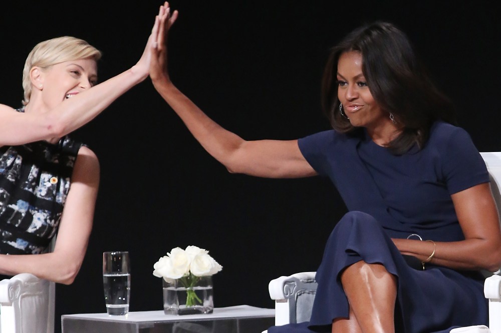 First Lady Michelle Obama receives a high five from actress Charlize Theron during the "Let Girls Learn" Global Conversation at The Apollo Theater on Sept. 29, 2015 in New York City. (Photo by Bennett Raglin/WireImage/Getty)