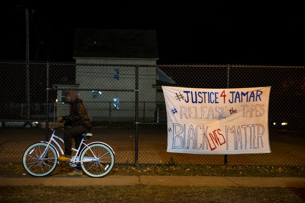 A man pauses on his bike while passing through the protests outside the 4th Precinct police station November 20, 2015 in Minneapolis, Minn. (Photo by Stephen Maturen/Getty)