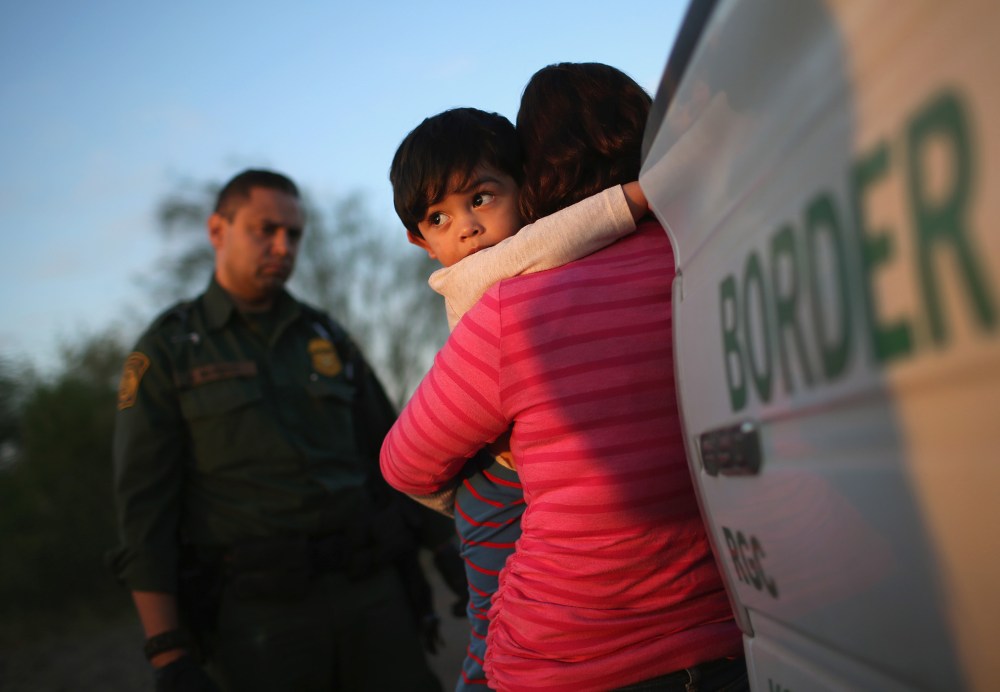 A one-year-old from El Salvador clings to his mother after they turned themselves in to Border Patrol agents after entering the country illegally on Dec. 7, 2015 near Rio Grande City, Texas. (Photo by John Moore/Getty)