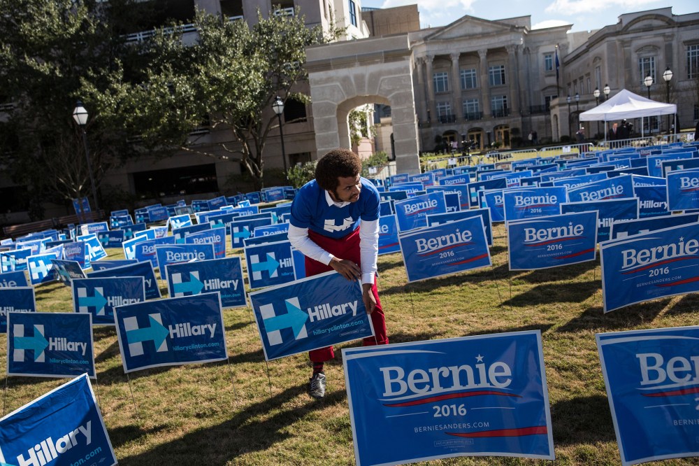 A man places signs supporting Hillary Clinton for the democratic presidential nominee outside the Gaillar Center prior to tonight's Democratic debate on Jan. 17, 2016 in Charleston, S.C. (Photo by Andrew Burton/Getty)