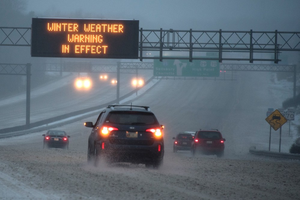 Vehicles move along Interstate 85 as an overhead sign indicates 'WINTER WEATHER WARNING IN EFFECT' during a winter storm on Jan. 22, 2016 in Greensboro, N.C. (Photo by Lance King/Getty)