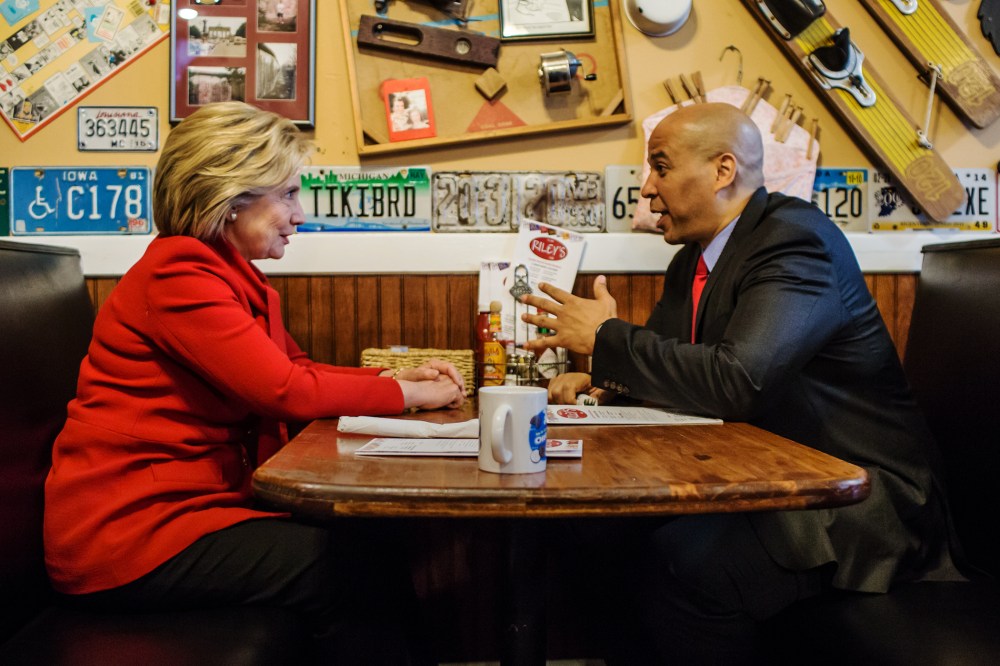 Democratic presidential candidate Hillary Clinton talks with Sen. Cory Booker (D-NJ) at Riley's Cafe on Jan. 24, 2016 in Cedar Rapids, Iowa. (Photo by Brendan Hoffman/Getty)