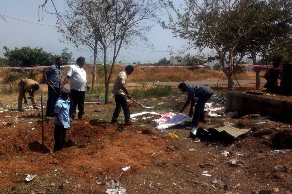 Indian authorities inspect the site of a suspected meteorite landing on Feb. 7, 2016 in Vellore district in southern Tamil Nadu state. The impact of the meteorite killed a bus driver and injured three others on Feb. 6. (Photo by STR/AFP/Getty)