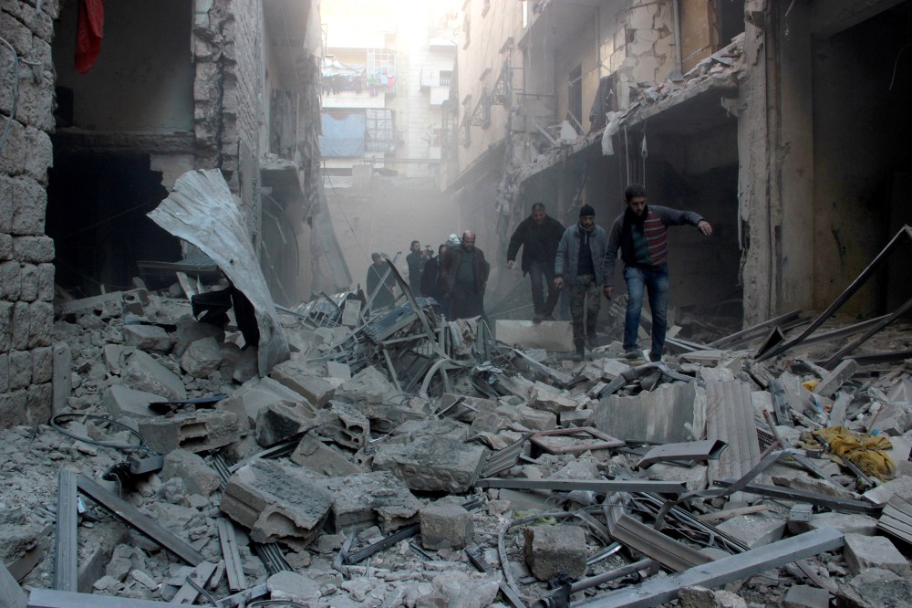 People walk past the rubbles as Russian airstrikes pound residential areas at opposition controlled Salihin neighborhood of Aleppo, Syria on Feb. 8, 2016. (Photo by Ibrahim Ebu Leys/Anadolu Agency/Getty)