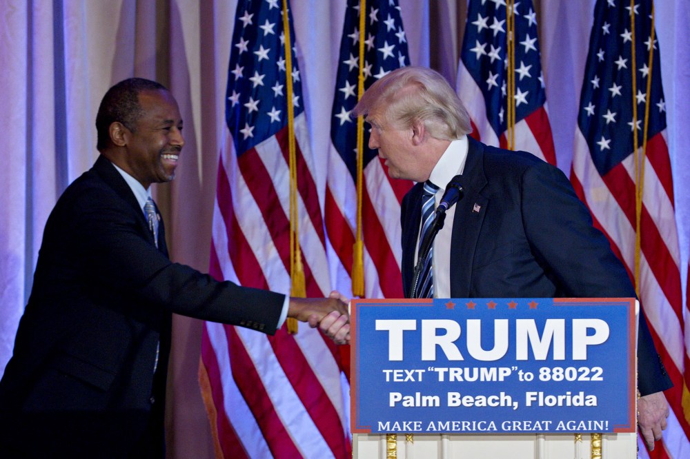 Donald Trump shakes hands with Ben Carson, retired neurosurgeon and former 2016 Republican presidential candidate, during a news conference at the Mar-A-Lago Club in Palm Beach, Fl., March 11, 2016. (Photo by Andrew Harrer/Bloomberg/Getty)