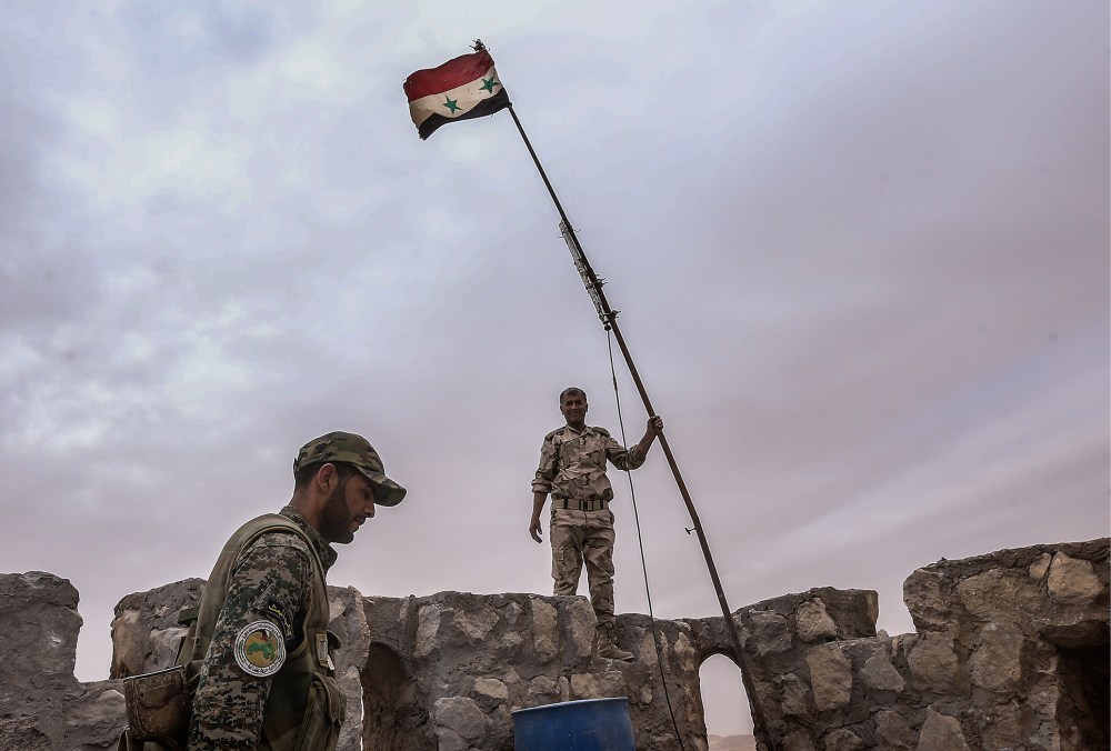 Syrian government army soldiers put a flag on top of Fakhr al-Din al-Maani Citadel, a UNESCO world heritage site. The Syrian Government's army has won control of the heritage site from ISIS militants. (Photo by Valery Sharifulin/TASS/Getty)