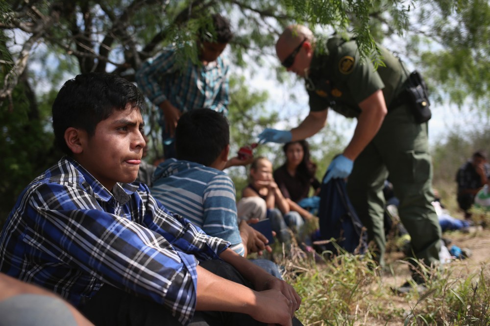 A Border Patrol agent collects personal items from Central American families who crossed into the United States seeking asylum on April 14, 2016 in Roma, Texas. (Photo by John Moore/Getty)