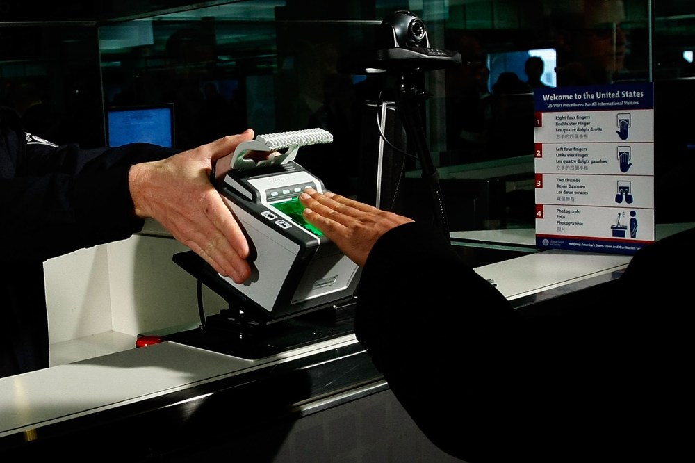 International airline passengers are fingerprinted on all ten fingers by a U.S. Customs and Border Protection officer on arrival at Dulles International Airport, Dec. 10, 2007 in Sterling, Va. (Photo by Win McNamee/Getty)