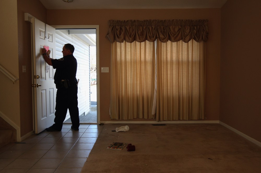 A sheriff's deputy tapes a "no trespass order" on the front door of a home, Feb. 18, 2009 in Longmont, Colo.  (Photo by John Moore/Getty)