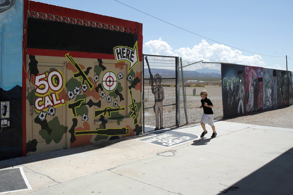 A young person runs by the Last Stop outdoor shooting range Wednesday, Aug. 27, 2014, in White Hills, Ariz. Gun range instructor Charles Vacca was accidentally killed Monday, Aug. 25, 2014 at the range by a 9-year-old with an Uzi submachine gun.