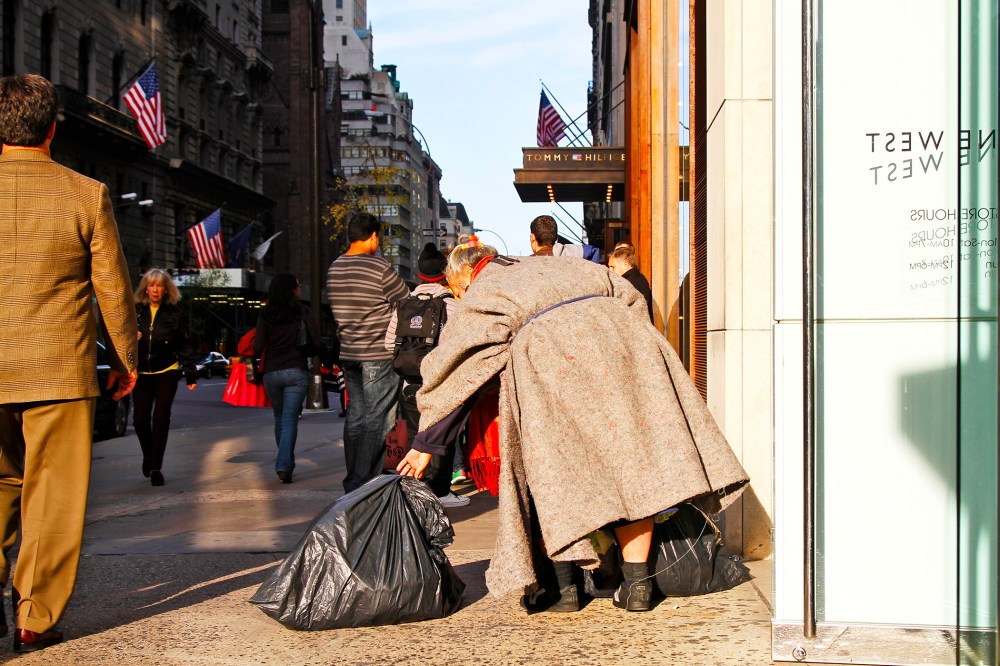A homeless women walks among shoppers on 5th Avenue in Manhattan.