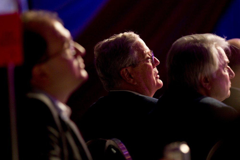 David Koch listens to Mitt Romney speak in Washington on Nov. 4, 2011.