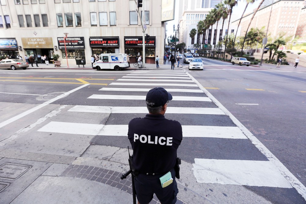 An LAPD officer watches a downtown intersection in Los Angeles, Calif., Dec. 17, 2013.