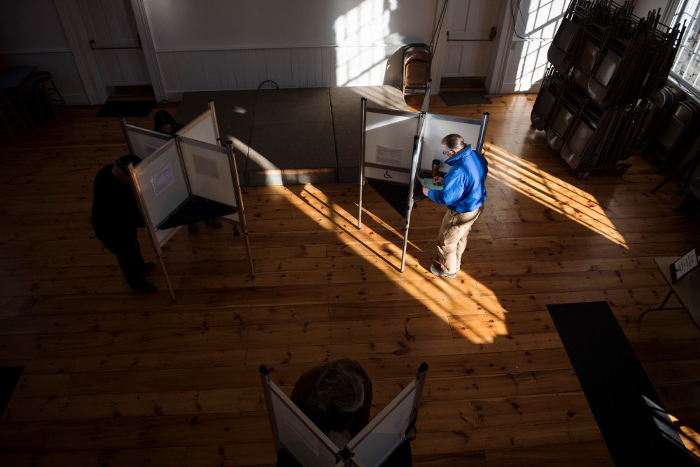 Voters cast their ballots in a polling station at the Ripton Town Clerk's office in Ripton, Vt.