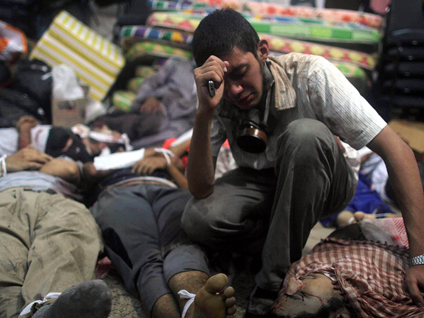 A young man mourns next to the bodies of protesters killed during the clearing of one of the two sit-ins of ousted president Morsi supporters, at the field hospital, near Rabaa Adawiya mosque, in Cairo, Egypt, on August 14, 2013. (Photo by Mosaab...