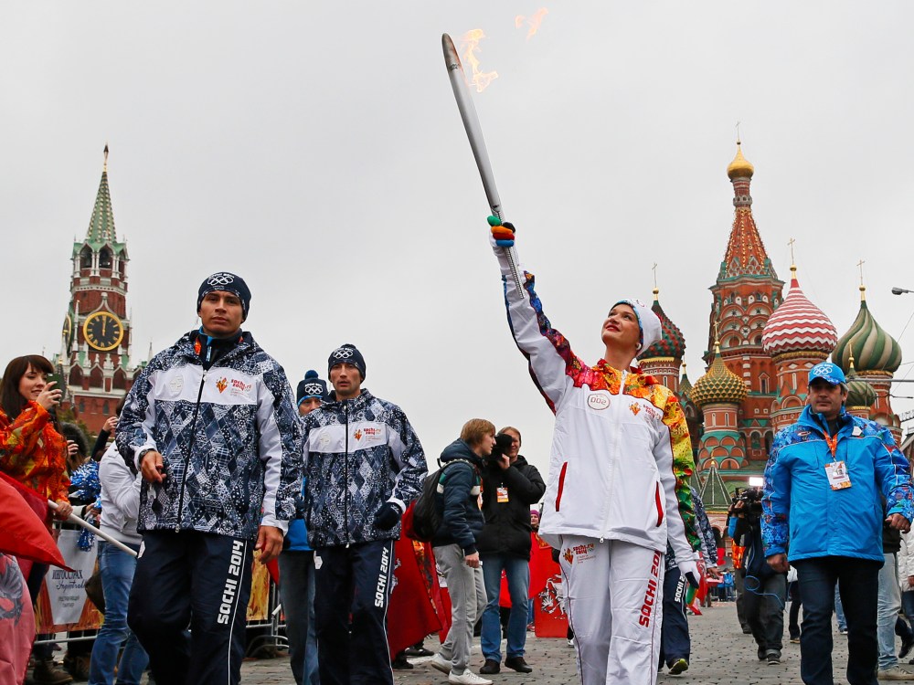 Russia's artistic gymnastics Olympic champion Svetlana Khorkina carries the Olympic flame during the start of the torch relay race in Moscow, October 7, 2012.