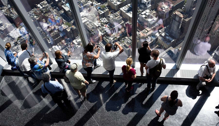 Visitors look out over city streets from the One World Observatory at One World Trade Center in New York, N.Y. on May 29, 2015. (Photo by Justin Lane/EPA)