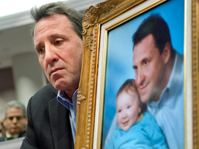Neil Heslin, holding a picture of himself with his son Jesse, testifies at the Legislative Office Building in Hartford, Conn. on Jan. 28, 2013.   (Photo by Jessica Hill/AP)
