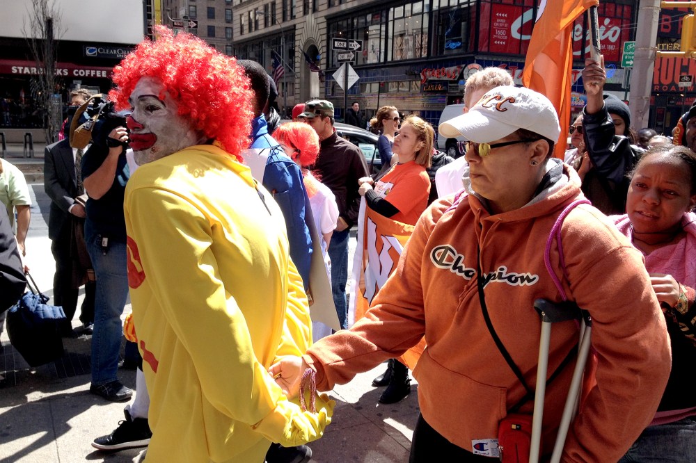 A protestor dressed as Ronald McDonald is given a mock "perp walk" during a protest against wages in the fast food industry, on April 3, 2014 in New York City.