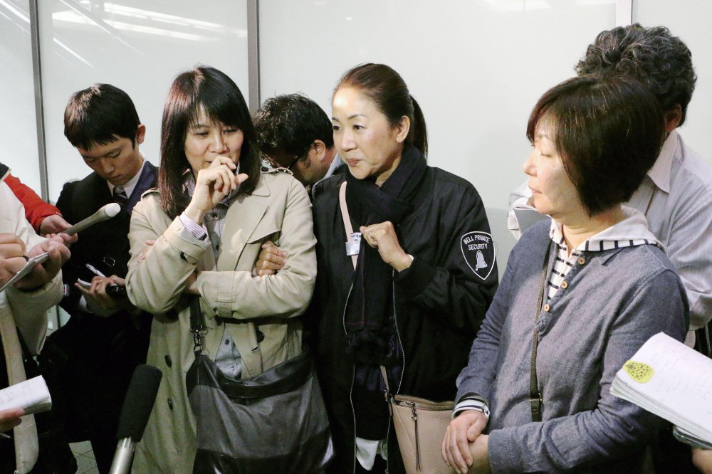 Passengers who escaped from an Asiana Airlines plane that skidded off a runway after landing at Hiroshima Airport speak to the media at the airport in Mihara, Hiroshima Prefecture, western Japan on April 14, 2015.