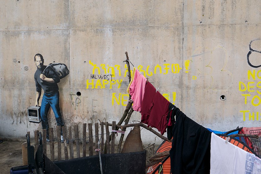 A Banksy mural in a refugee camp in Calais, France, depicts Steve Jobs. (Photo by Banksy)
