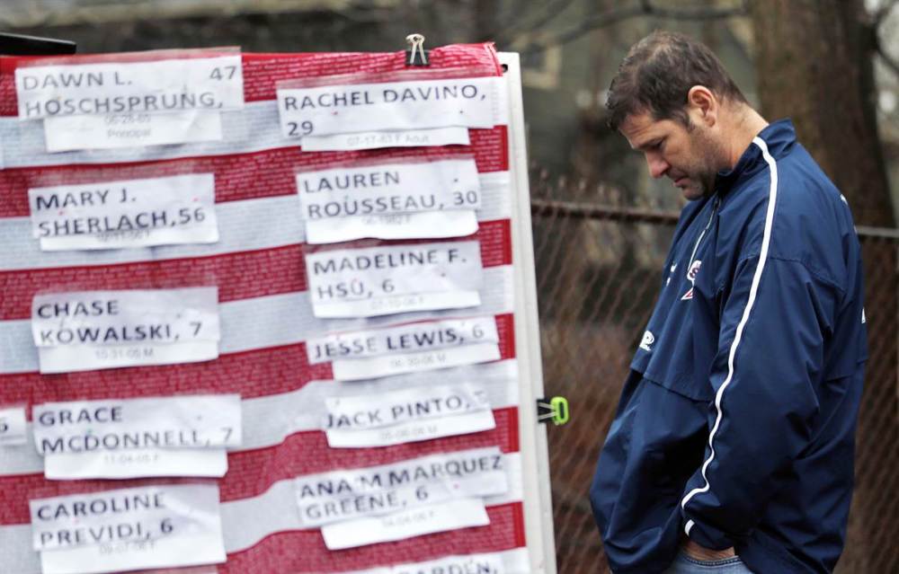 A man in Newtown, Connecticut, pays his respect to the victims killed at Sandy Hook Elementary School. (Julio Cortez / AP)