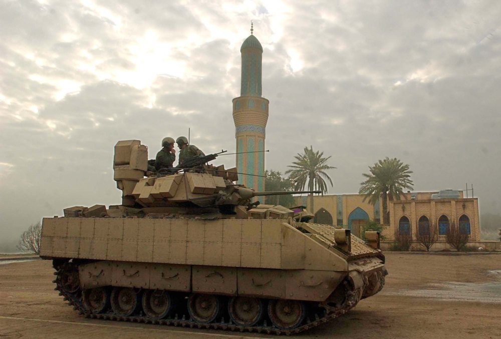U.S Army soldiers of the 1st Battalion, 22nd Regiment, (1-22) of the 4th Infantry Division, talk onboard their M1 tank in front of a mosque in Tikrit, Iraq. (AP Photo/Gregorio Borgia)