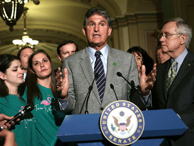 Standing alongside Senate Majority Leader Harry Reid and family members of Newtown victim, Sen. Joe Manchin speaks as after a vote on the Senate floor April 17, 2013 in Washington, DC. (Photo by Alex Wong/Getty Images)