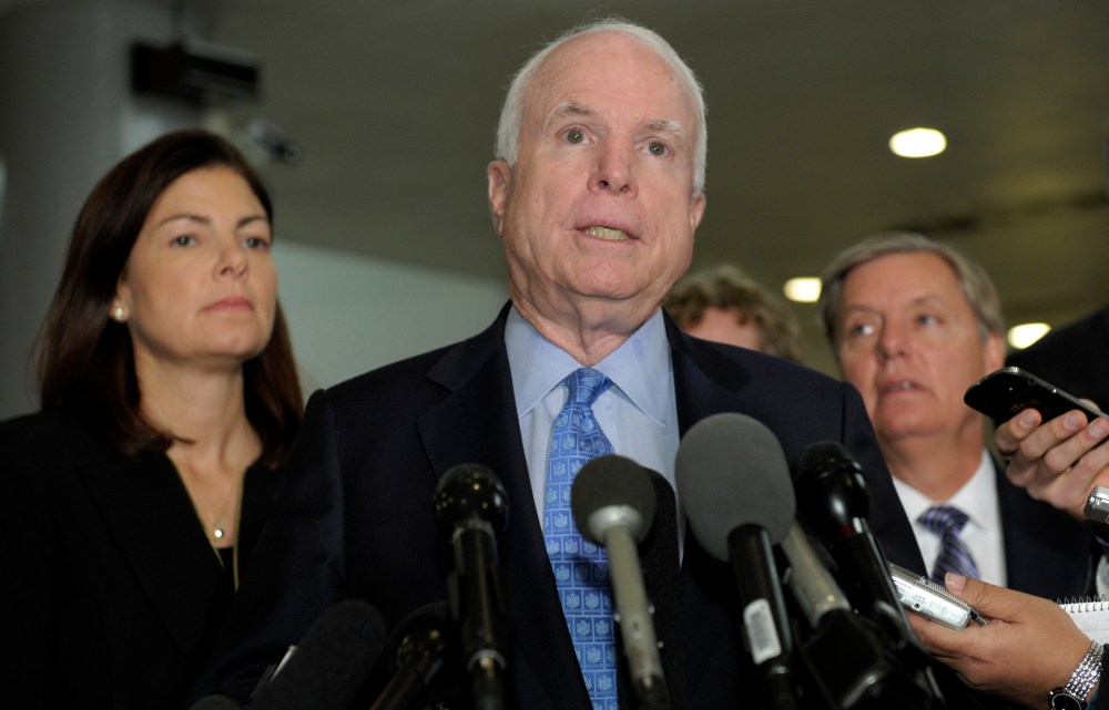 Sen. John McCain, R-Ariz., ranking Republican on the Senate Armed Services Committee, center, flanked by fellow committee members, Sen. Kelly Ayotte, R-N.H., left, and Sen. Lindsey Graham, R-S.C., right, speaks on Capitol Hill in Washington, Tuesday,...