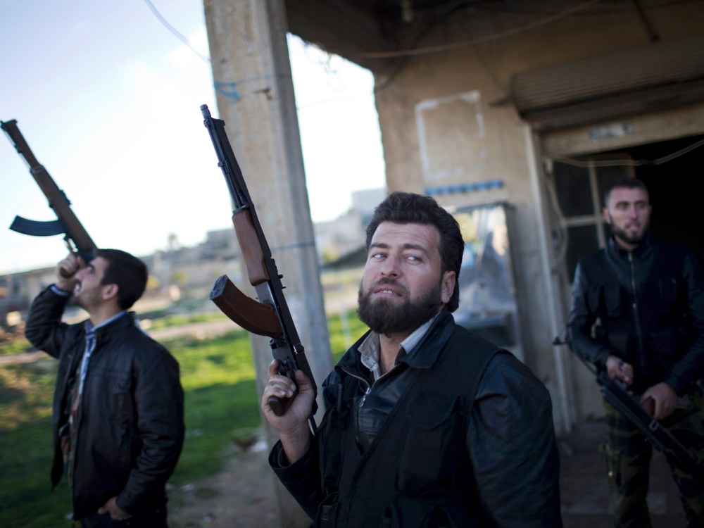 Free Syrian Army fighters look at a Syrian Army jet, not pictured, in Fafeen village, north of Aleppo province, Syria, Tuesday. (Photos by Manu Brabo/AP)