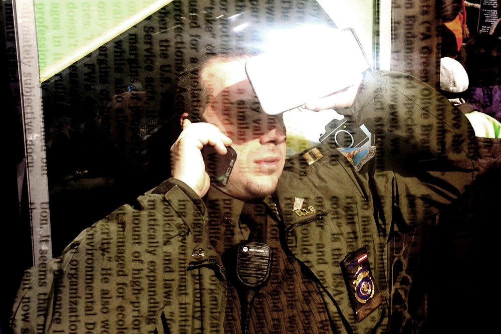 A man talks on the phone while blocking the sun with another cell phone.