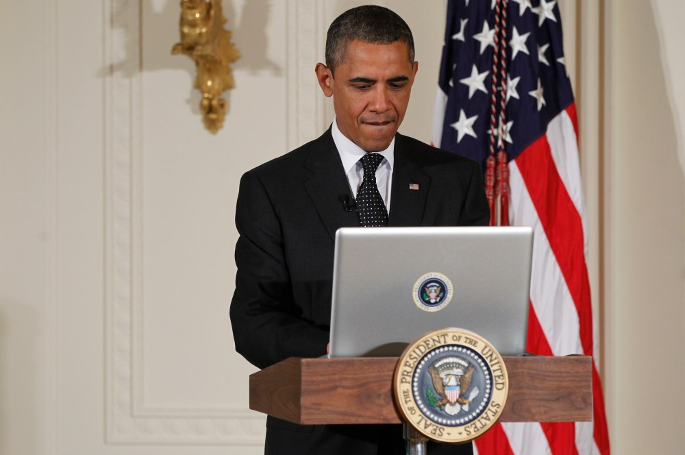 President Barack Obama uses a laptop computer to send a tweet during a "Twitter Town Hall" in the East Room of the White House in Washington, Wednesday, July 6, 2011.