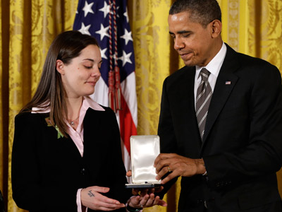 President Obama presents a 2012 Citizens Medal to Erica Lafferty in honor of her mother, Sandy Hook Elementary School Principal Dawn Hochsprung, on Feb. 15, 2013, in the East Room of the White House in Washington. (Photo by Jacquelyn Martin/AP)