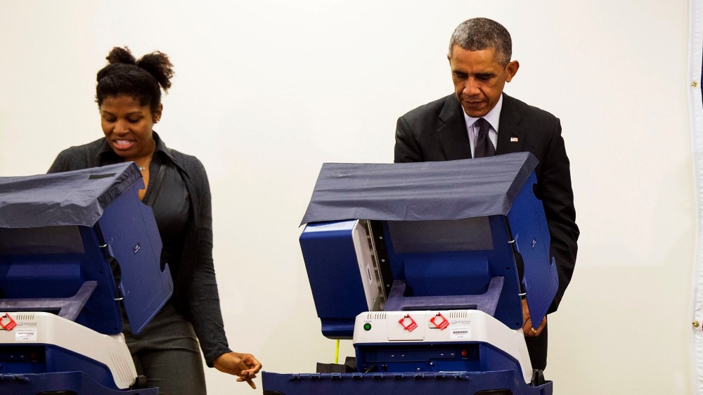 President Barack Obama votes next to Aia Cooper at the Dr. Martin Luther King Community Service Center in Chicago, Ill. on Oct. 20, 2014.