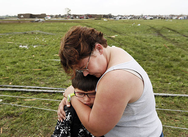 Rebekah Stuck hugs her son, Aiden Stuck, 7, after she found him in front of the destroyed Briarwood Elementary after a tornado struck south Oklahoma City and Moore, Okla., Monday, May 20, 2013. Aiden Stuck was inside the school when it was hit. (AP...