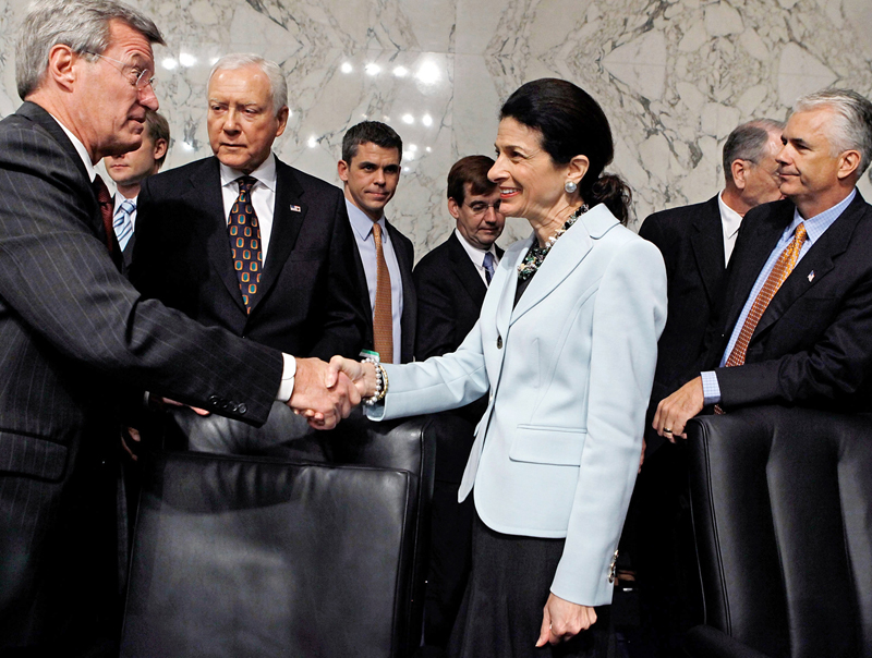 Senate Finance Committee Chairman Max Baucus (D-MT) (L) thanks Sen. Olympia Snowe (R-ME) for voting in favor of health care reform legislation as committee Republicans Sen. Orrin Hatch (R-UT) and Sen. John Ensign (R-NV) watch, on Capitol Hill October...