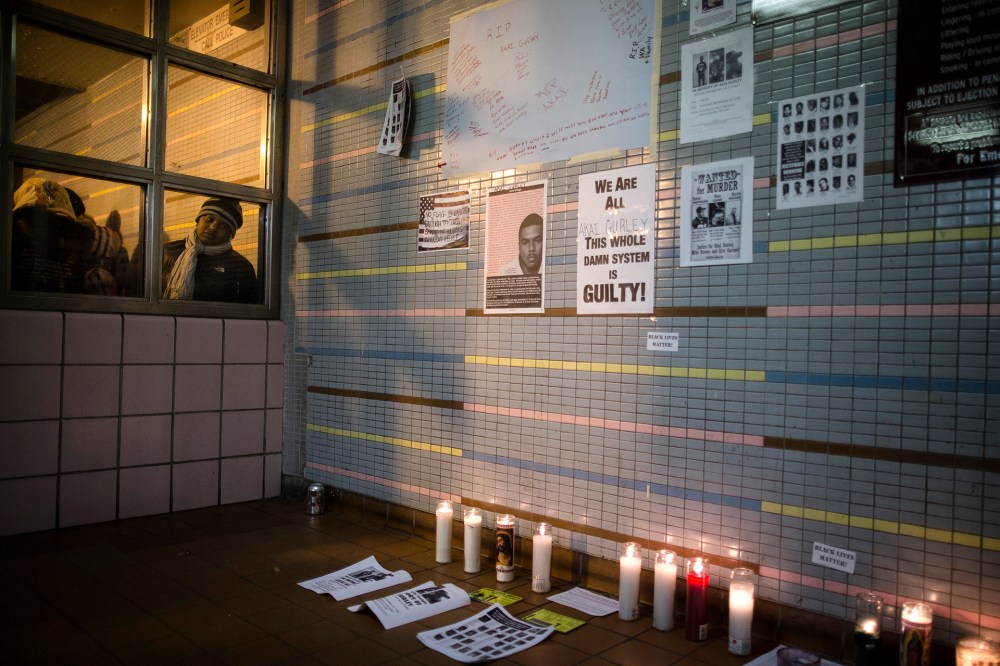 A demonstrator looks on a memorial to Akai Gurley who was shot to death by rookie NYPD officer Peter Liang at the Louis Pink Houses public housing complex on Nov. 22, 2014, in the Brooklyn borough of New York.