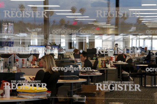 Arts writer Richard Chang, center, works on his computer in the newsroom of the Orange County Register in Santa Ana, Calif., Thursday, Dec. 27, 2012. After years of demoralizing layoffs, one newspaper is trying something novel: hiring more reporters. ...