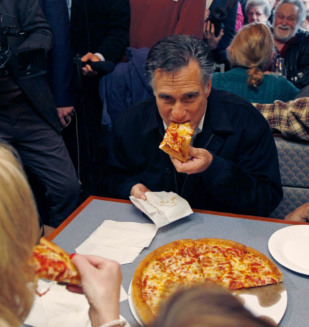 Republican presidential candidate former Mass. Gov. Mitt Romney takes a bite of pizza during lunch with his wife Ann while campaigning at Village Pizza in Newport, N.H., Wednesday Dec. 20, 2011. (AP Photo/Charles Krupa)