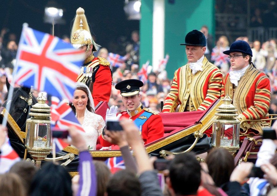 Britain's Prince William and his wife Kate, Duchess of Cambridge, are driven through the crowd, following their wedding in London, April 29, 2011. (Photo by Jonathan Short/AP)