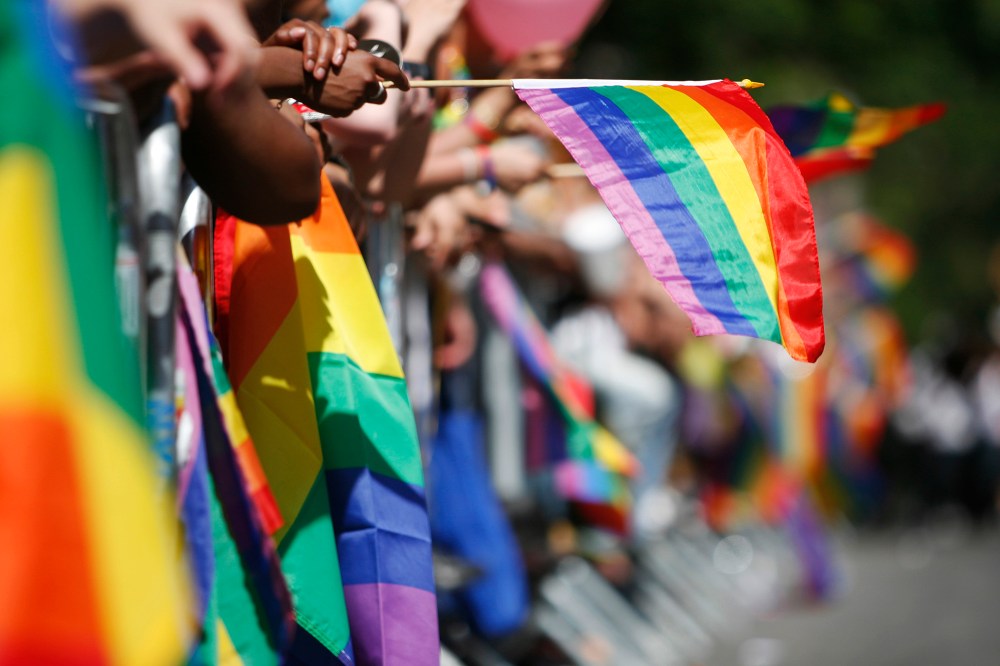 The sidewalks are filled with rainbow flags as revelers celebrate Gay Pride.