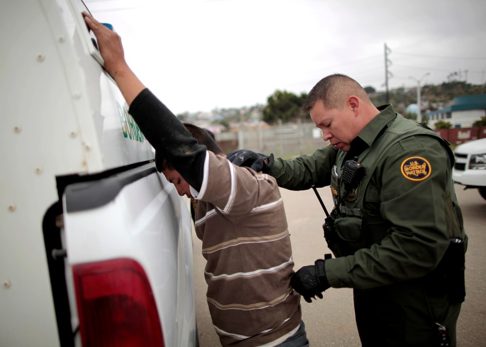 A United States border patrol agent catches an undocumented immigrant crossing from Mexico to the U.S. in San Ysidro