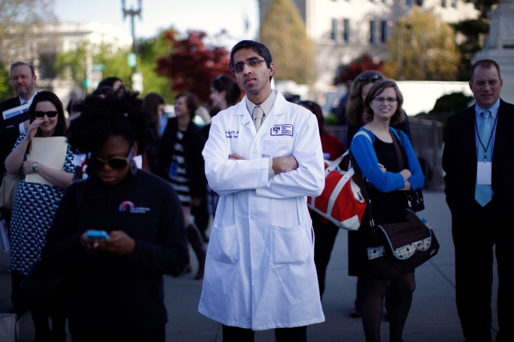 Doctor Vivek Murthy stands among other bystanders outside the Supreme Court in Washington, March 26, 2012.