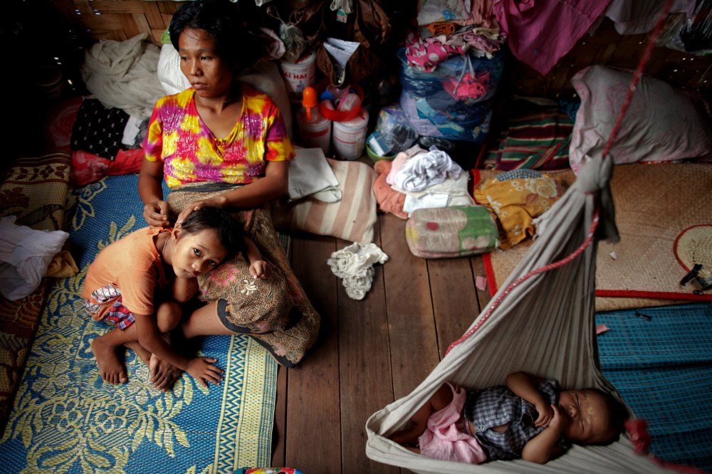 HIV-positive Ma Mon comforts her non-positive daughter Myat Noe Thu as her HIV-positive son Ei Ei Phyu sleeps in a hammock at the HIV/AIDS hospice founded by a member of the National League for Democracy (NLD) party in the suburbs of Yangon. Myanmar on Ma