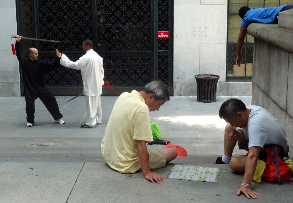 Local residents relax in a square in Chinatown in New York, Aug, 6, 2012. (Photo by Charles Platiau/Reuters)
