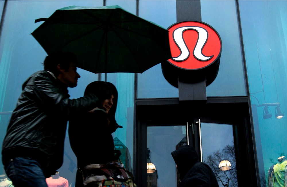 Pedestrians walk past a Lululemon Athletica store in New York