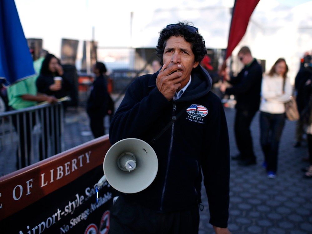 Man with megaphone announces closure of Statue of Liberty, a U.S. National Park, due to U.S. Government shutdown, to tourists at the ferry dock in Battery Park in New York