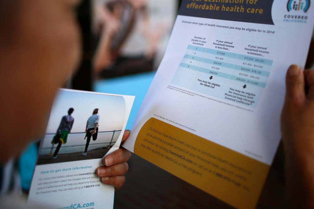 A potential insurance customer browses leaflets at a "Covered California" event in Los Angeles on Oct. 1, 2013.